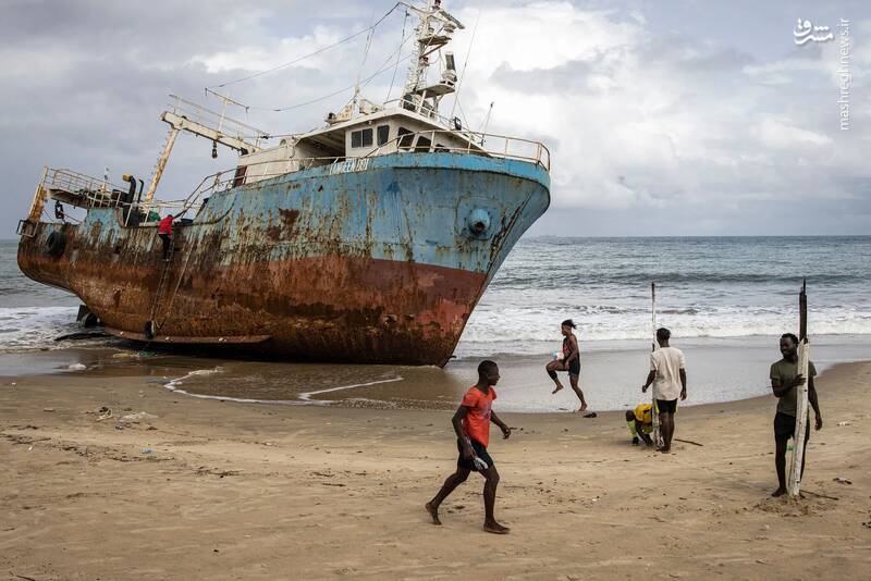 فوتبالیت‌های محلی در کنار یک کشتی پهلوگرفته در ساحل دروازه‌ای را برپا می‌کنند./ فری تاون _ سیرالئون